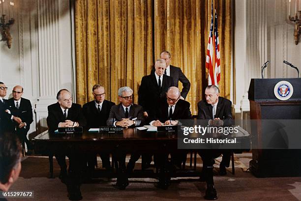 President Lyndon B. Johnson watches the signing of an international treaty banning weapons in outerspace, January 27, 1967 -- the same day three...