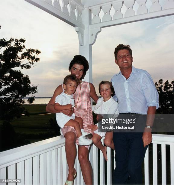 President John F. Kennedy and his wife Jacqueline sit with their children Caroline and John, Jr., at Hyannisport, Massachusetts.