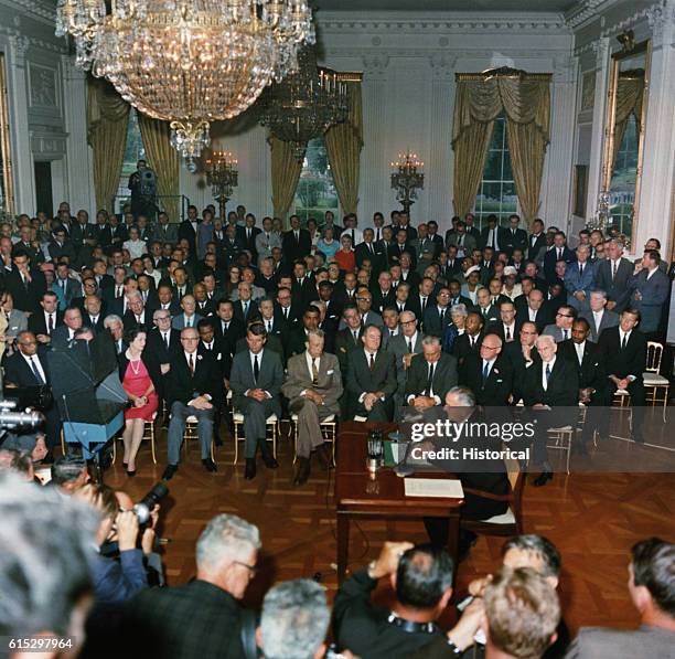 President Lyndon B. Johnson signs the Civil Rights Act of 1964 in the presence of civil rights leaders, government dignitaries, and the press. July...