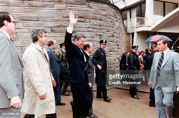 American politician US President Ronald Reagan smiles and waves as he leaves the Washington Hilton Hotel, Washington DC, March 30, 1981. Among those...