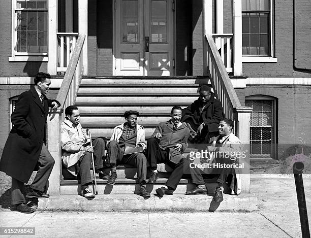 Group of Howard University students relax on the stoop of a building. Washington, DC, Winter 1942.