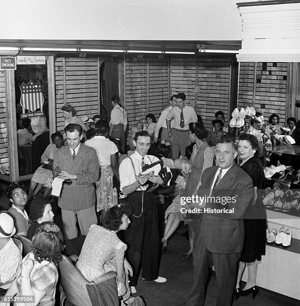 Number of people crowd into a shoe store on the last day for War Ration shoe coupon 17. Washington, DC, June 1943.