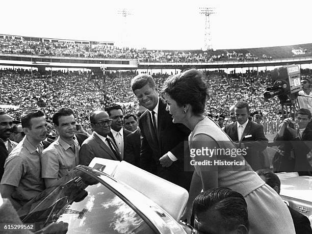 President John F Kennedy looks on as Jacqueline Kennedy speaks in Spanish to the soldiers of the Bay of Pigs Brigade from an open car. Miami,...