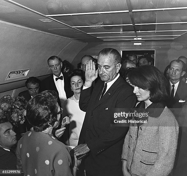 President Lyndon B. Johnson takes the oath of office aboard Air Force One after the assassination of John F. Kennedy. Kennedy's wife Jacqueline and...