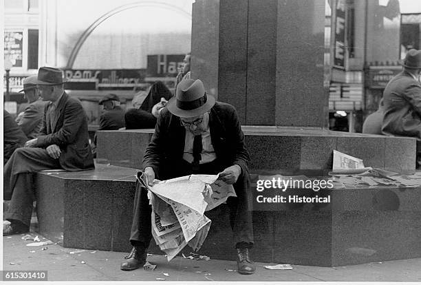 Man reading a newspaper in Fountain Square in Cincinnati, Ohio. October 1938.