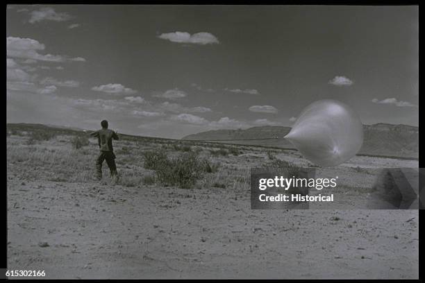 Man Holding Research Balloon in Desert