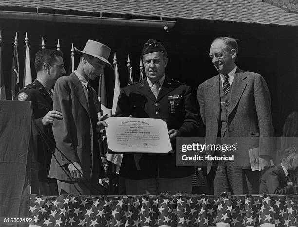 General Leslie Groves presents the Army-Navy "E" Production Award to the University of California's lab at Los Alamos for the production of the...