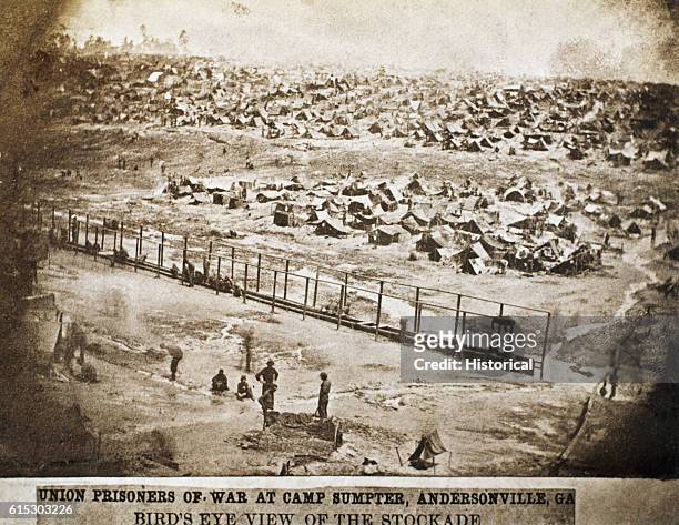 Few federal prisoners of war squat along a long slit trench used as a latrine at Andersonville, Georgia. Originally known as Camp Sumter, the...