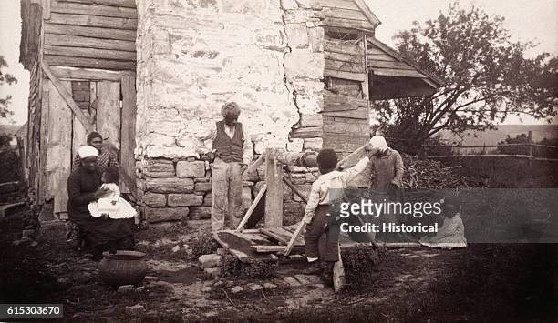 Family of former slaves outside their ramshackle house in Fredericksburg, Virginia, ca. 1862-1865.