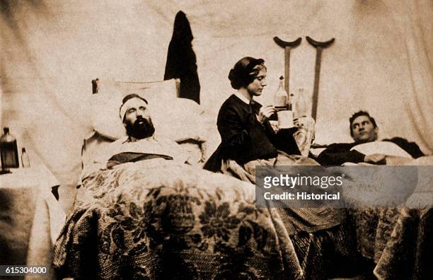 Two wounded Federal soldiers are cared for by Anne Bell, a nurse during the American Civil War.