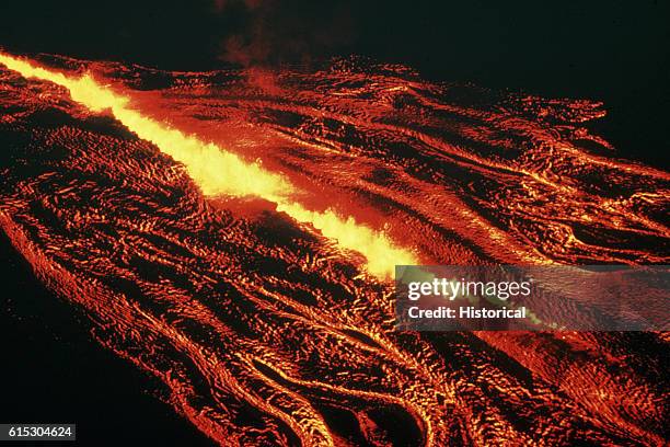 Crack opens in a cooling mass of lava, revealing the red-hot liquid beneath. Hawaii.