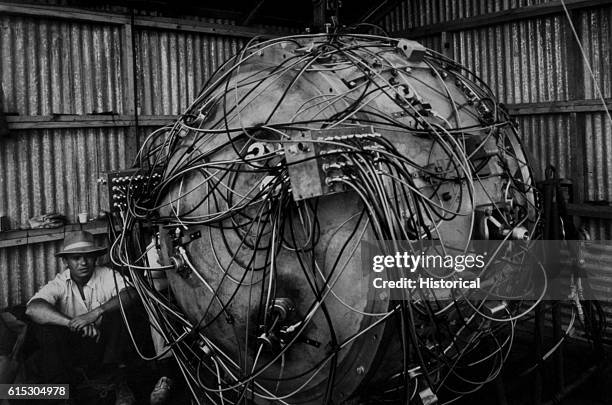 Physicist Norris Bradbury sits next to The Gadget, the nuclear device created by scientists to test the world's first atomic bomb, at the top of the...