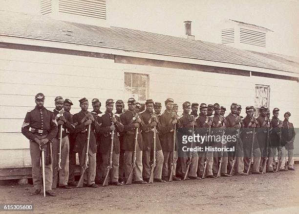 Men of Company E of the 4th United States Colored Troops stand outside their barracks at Fort Lincoln.