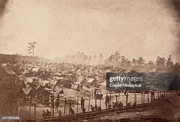 Few federal prisoners of war squat along a long slit trench used as a latrine at Andersonville, Georgia. Originally known as Camp Sumter, the...