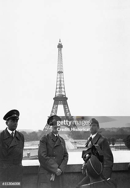 Adolf Hitler, accompanied by his chief architect and adjutant Albert Speer and sculptor Arno Breker, stands on a balcony before the Eiffel Tower,...