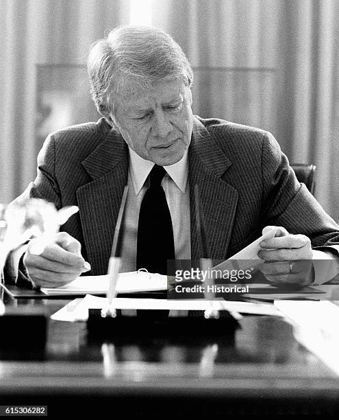 United States President Jimmy Carter reads over some documents in his office.