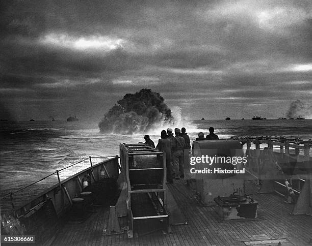 Coast Guardsmen on the deck of the U.S. Coast Guard Cutter Spencer watch the explosion of a depth charge which blasted a Nazi U-boats's hope of...