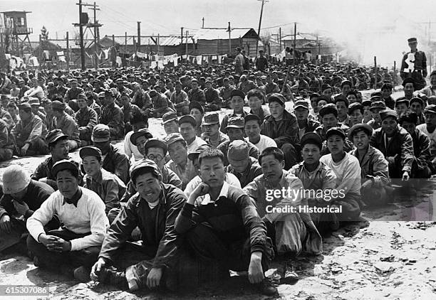 At the United Nations' prisoner-of-war camp at Pusan, Korea in April 1951, prisoners are assembled in one of the camp compounds. The camp contains...