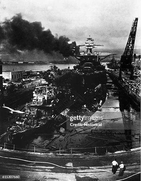Japanese attack on Pearl Harbor. Wrecked USS Downes at left and USS Cassin at right. In the rear is the USS Pennsylvania 100-ton Flagship of the...