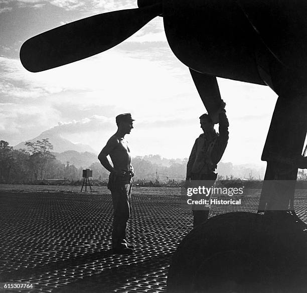 American ground crewmen at Piva strip chat next to an F4U Corsair fighter. They are waiting for orders to prepare the aircraft for an impending...