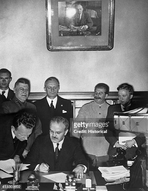 Soviet Foreign Minister Vyacheslav Molotov signs the German-Soviet nonaggression pact in Moscow on August 24, 1939 as German foreign minister Joachim...