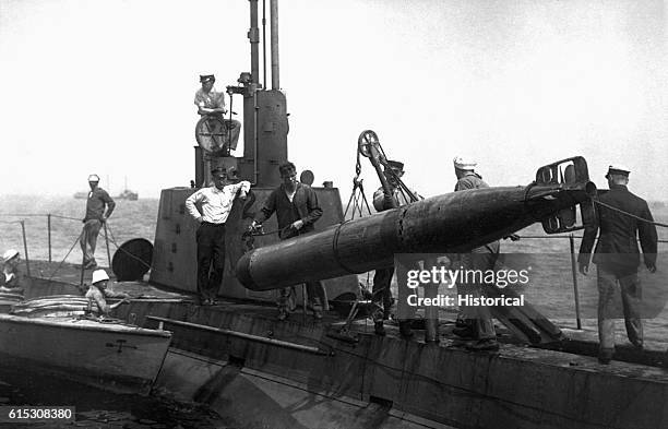 Sailors recover a torpedo from the ocean, ca. 1918. | Location: top deck of submarine.