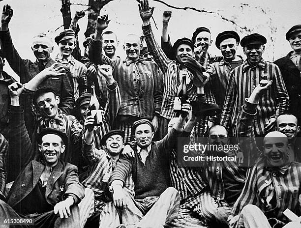 Liberated Polish inmates from the Dachau concentration camp raise bottles of wine and celebrate.