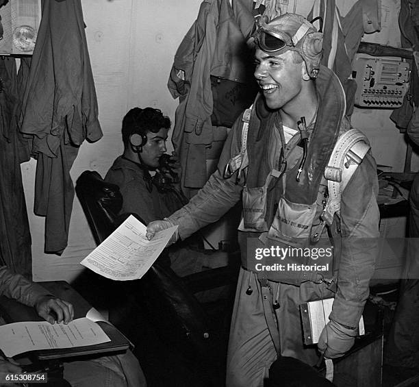 After a successful mission, a USS Lexington aircrewman turns in a report in the ready room. November 1943. | Location: USS Lexington.