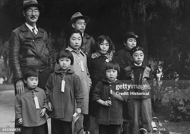 The Mochida family awaits a bus that will eventually take them to an interment camp, Hayward, California, May 8, 1942. They, along with some 112,000...