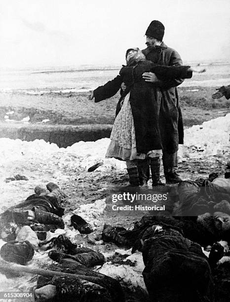 Man attempts to console a woman who grieves after she finds someone she knows among those murdered by the Nazis. Soviet Union, ca. 1940s.