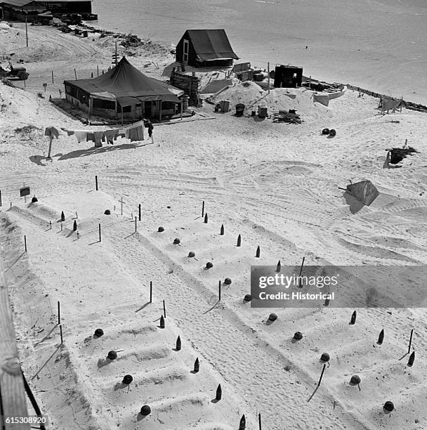 Artillery shells and helmets temporarily mark the graves of Marines who died taking Tarawa. November 1943.
