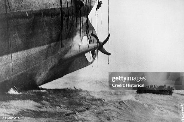 Men slide down ropes during a last minute escape from a vessel that was torpedoed by a German U-boat in 1917.