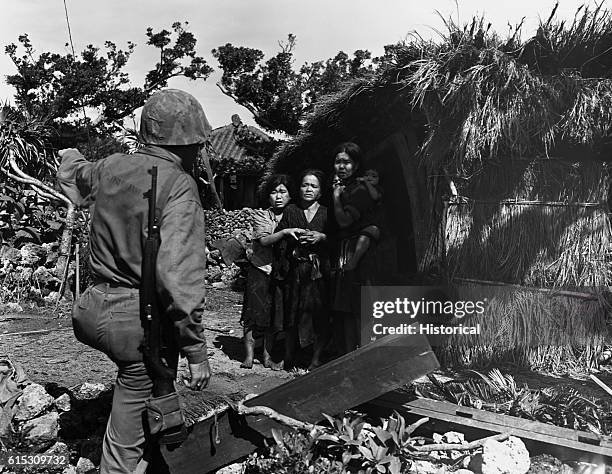 Marines stormed ashore at Agune Jima, 30 miles west of Okinawa on June 9, 1945. Lt. H.P. Barrand talks with three native women after the invasion....