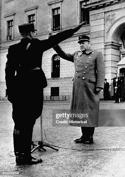 Vidkun Quisling, head of the Norwegian Nazi Party and appointed leader of the Norwegian government by the German invaders, uses the Nazi salute to...