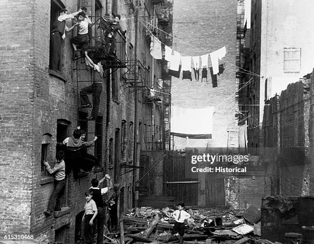 Group of boys use the tenement housing environment as a playground. From the series One Third of a Nation, New York City.