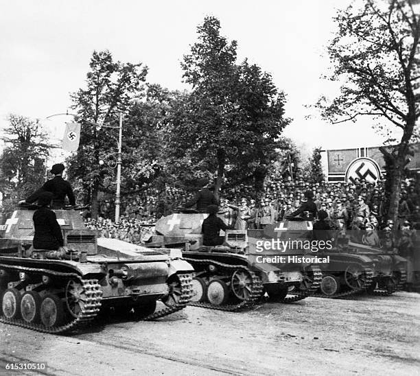 The Panzers, German tanks, on parade in Poland after the German invasion. Hitler salutes as they pass.