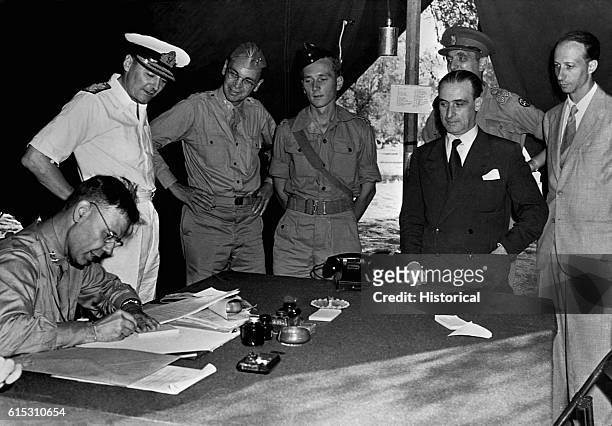 Maj. Gen. Walter B. Smith , Chief of Staff to General D. Eisenhower signs armistice ending hostilities between Allied and Italian forces.