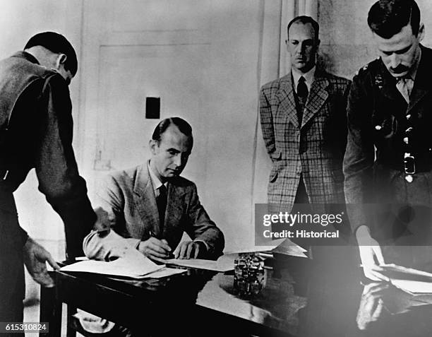 Major Eugene Werner of the SS signs the documents of unconditional surrender for all German troops in Italy and western Austria at Allied Forces'...