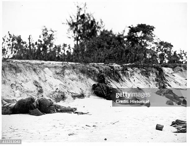 Marine casualties lie on the beach near Charan-Kanoa, Saipan Island, following the landings during the Battle of Saipan in World War II. | Location:...