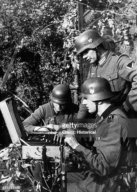 German Signal troops communicate by using what is described as a "teletype" but which actually resembles the Enigma encoding machine.