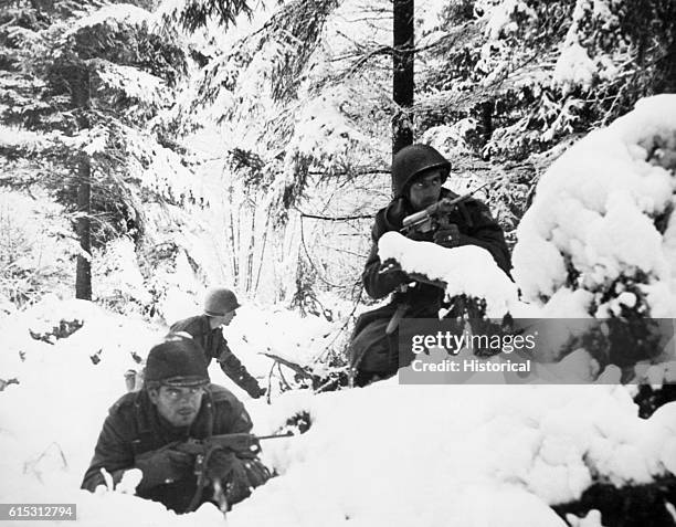 Troops in a snow covered forest during the Battle of the Bulge. Belgium, ca. 1944