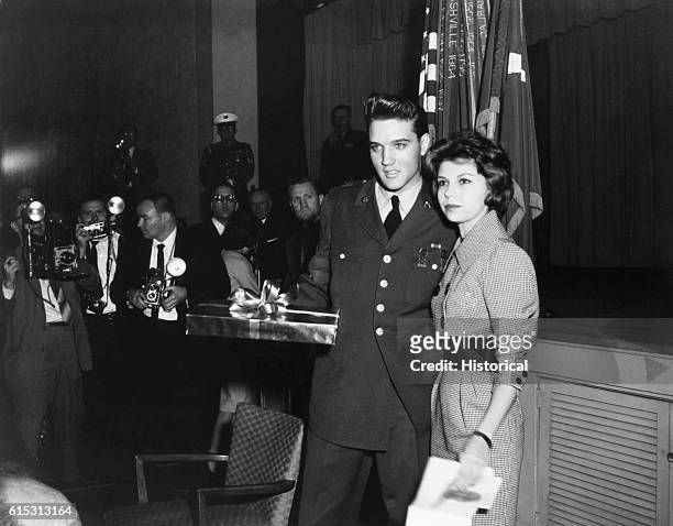 Singer Nancy Sinatra walks with Elvis Presley on his last day in military service, March 1960.
