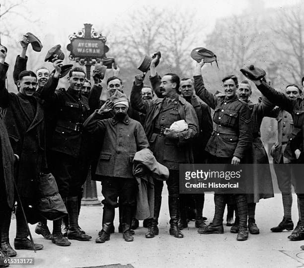 Allied soldiers in Paris wave their caps in recognition of the armistice, 11th November 1918.