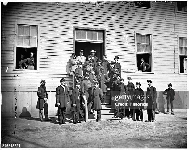 Soldiers pose with surgeons of Harewood Hospital in front of the hospital building in Washington, D.C., ca. 1860s.