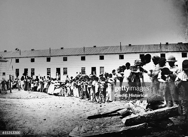 African Americans stand outside a contraband school, or Freedman's Village, in Arlington, Virginia, ca. 1860s.