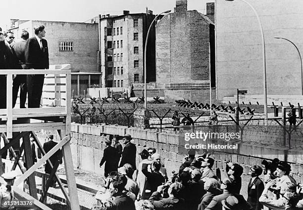 President John F. Kennedy looks at the Berlin Wall from his speaking platform, just before his famous "Ich Bin Ein Berliner" speech. June 26, 1963.