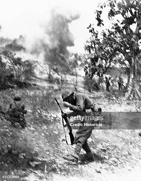 Marine starts to fall after being struck by shrapnel from an exploding Japanese mortar shell on Saipan during World War II.