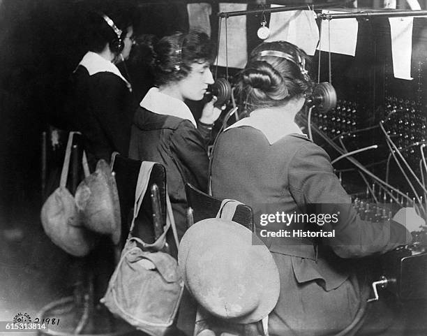 Telephone operators working with the U.S. Signal Corps work at a switchboard in American military headquarters at St.-Mihiel, France. Gas masks and...