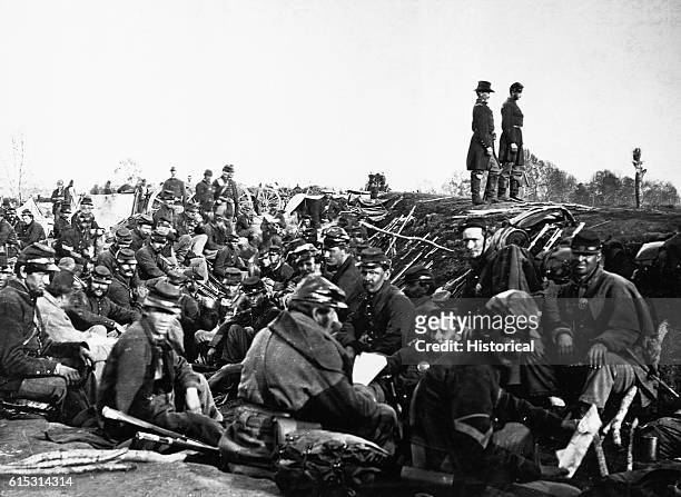 Soldiers sit in the trenches while officers scout the field at Petersburg, Virginia, ca. 1861-1865. | Location: near Petersburg, Virginia, USA.