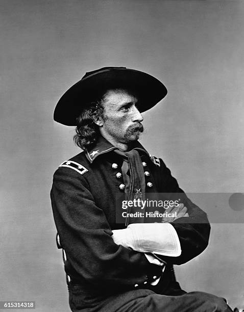 Seated right-profile of George Armstrong Custer in major general's uniform, some time after October 19, 1864. The uniform features long gloves,...